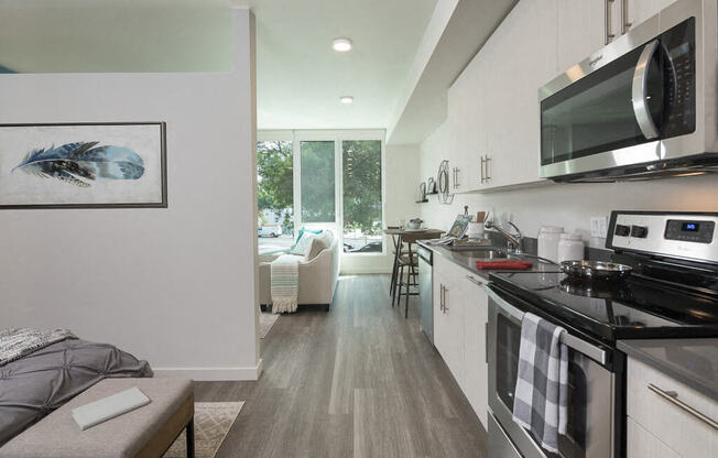 A modern kitchen with a grey floor and white cabinets. at Ravello Apartments, Washington