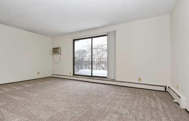 Fridley, MN Georgetown Apartment. A living room with a large window and a carpeted floor