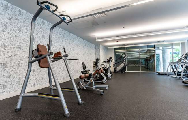 a gym with various exercise equipment in a building with a glass door