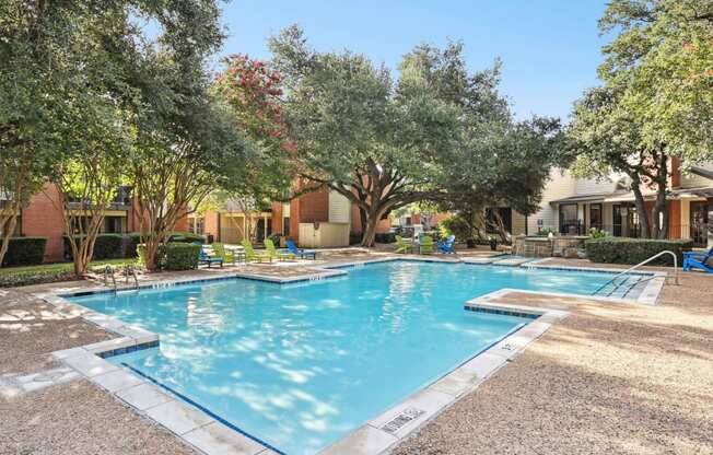 Swimming pool with trees and apartment buildings at Hunters Chase in Austin, TX