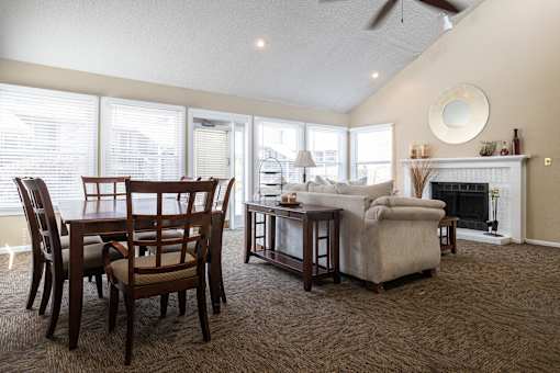 A cozy clubhouse living room with plush seating and a fireplace.