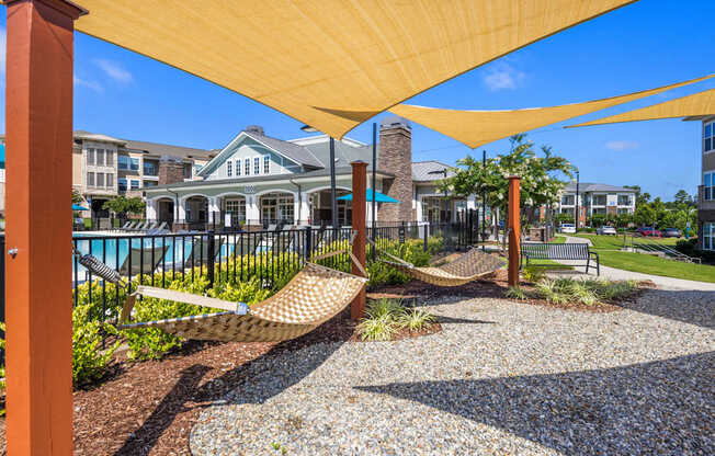 A yellow canopy over a gravel area with a hammock.