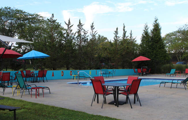 a patio with a table and chairs and a swimming pool in the background