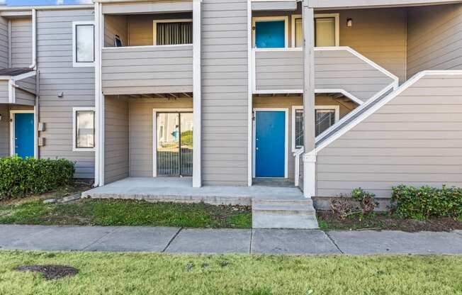 the entrance to an apartment building with stairs and a blue door