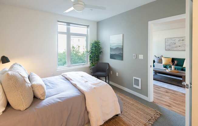 A bedroom with a bed, a chair, and a painting on the wall.