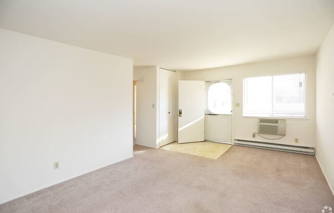 an empty living room with white walls and a carpet floor