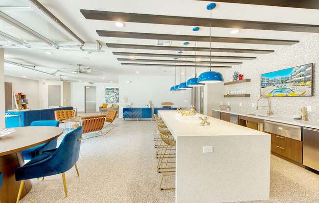 A kitchen with a long table and blue chairs.