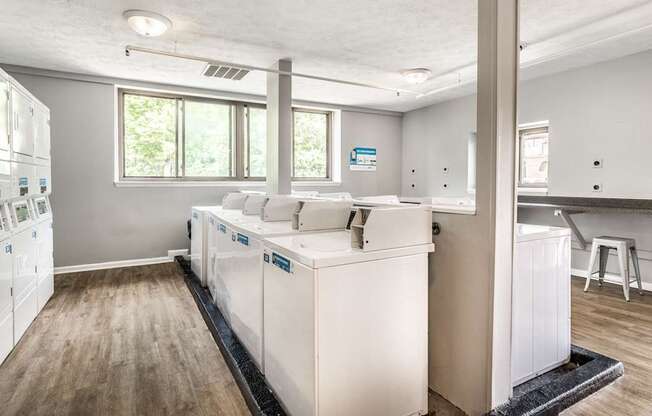 A kitchen with white appliances and wooden floors
