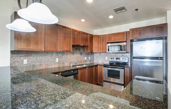 A kitchen with granite countertops and stainless steel appliances.