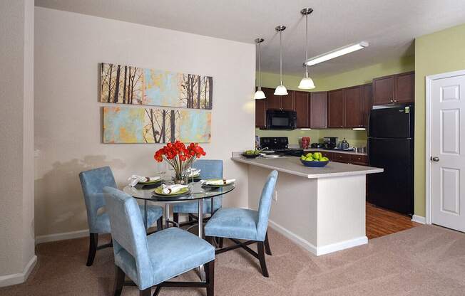 a dining room and kitchen with a table and chairs