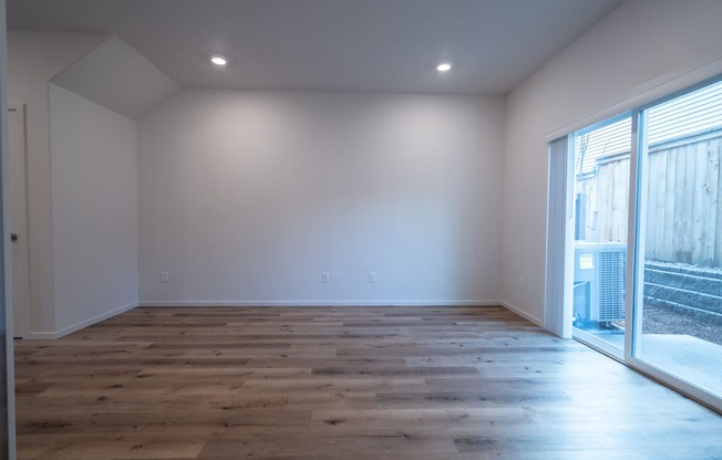 a bedroom with hardwood floors and white walls