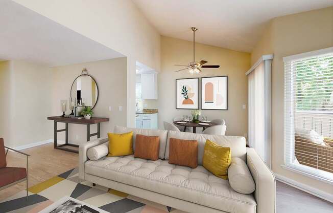 A living room with a white couch and a rug on the floor.