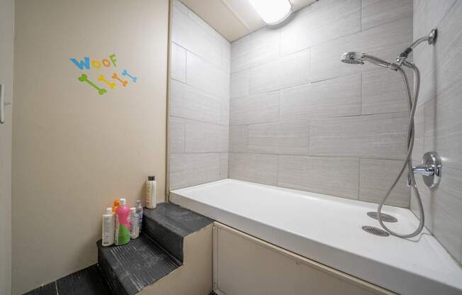 A bathroom with a bathtub and a shower head.