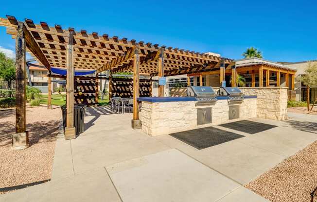 the backyard has a patio with a stone grill and a pergola