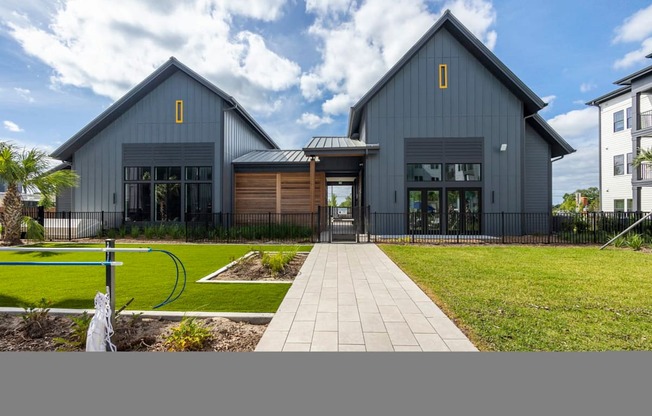 A modern house with a grey exterior and a black fence.