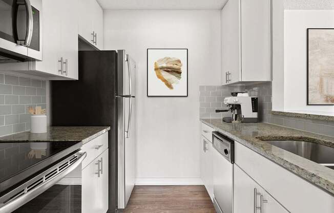 A kitchen with white cabinets and a black refrigerator.