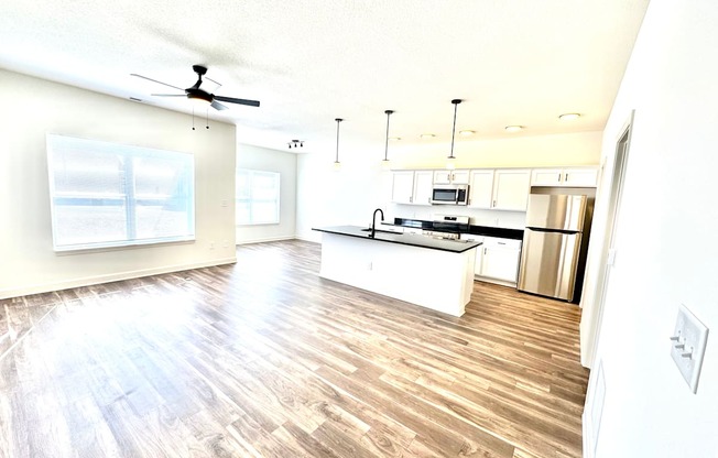 A kitchen with a wooden floor and white walls.