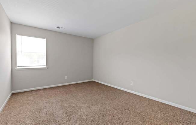 an empty room with carpet and a window