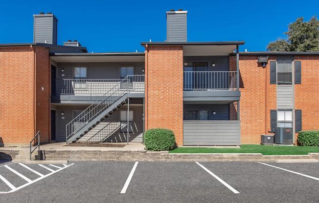 an empty parking lot in front of a brick building