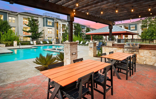 an outdoor patio with tables and a swimming pool