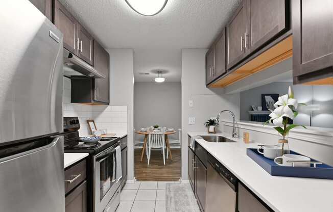 an open kitchen with stainless steel appliances and a dining room with a table