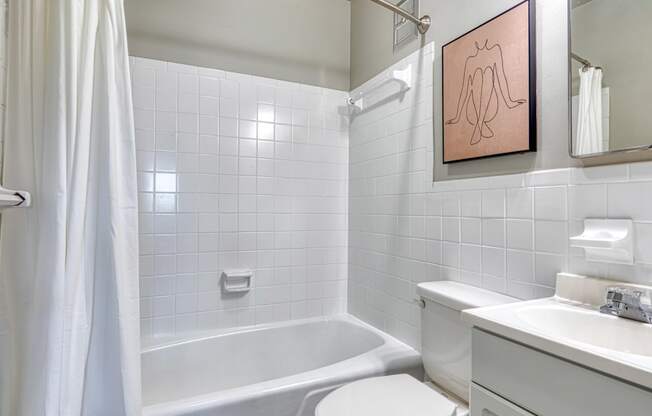 a white bathroom with a tub and a sink and a toilet