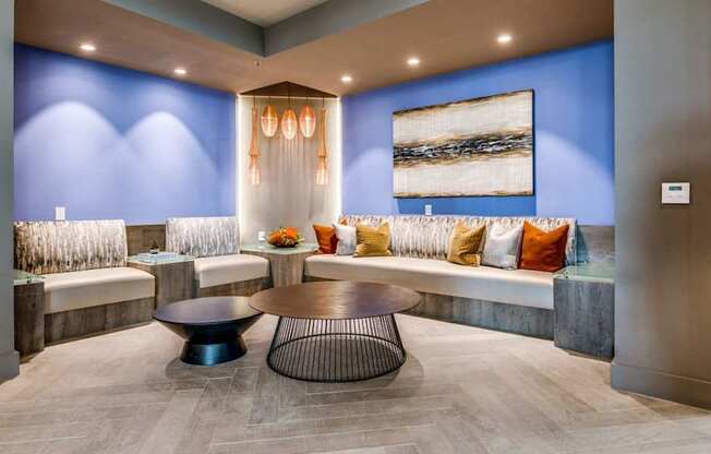 A modern waiting room with a blue wall and a large painting.