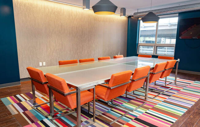 a conference room with a long table and orange chairs