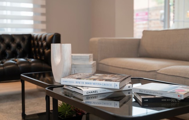 a pile of books on a coffee table in a living room