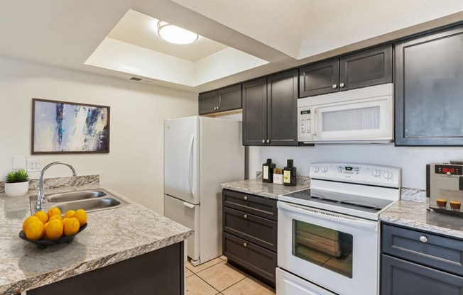 kitchen with white appliances and granite counter tops and black cabinets