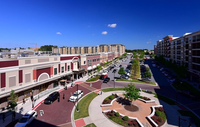 A city street with cars and buildings on either side.