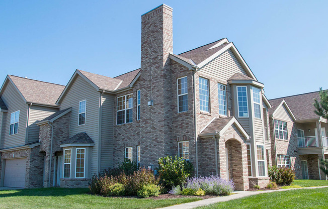 a villa building with brick and stone exterior on a sunny day