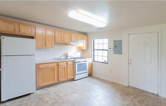 A kitchen with wooden cabinets and a white refrigerator at Dutch Village Apartments, Baltimore, 21234