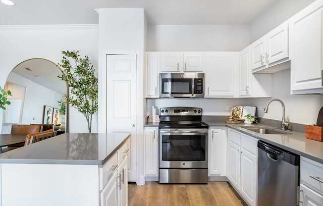 A modern kitchen with a stainless steel oven and white cabinets.