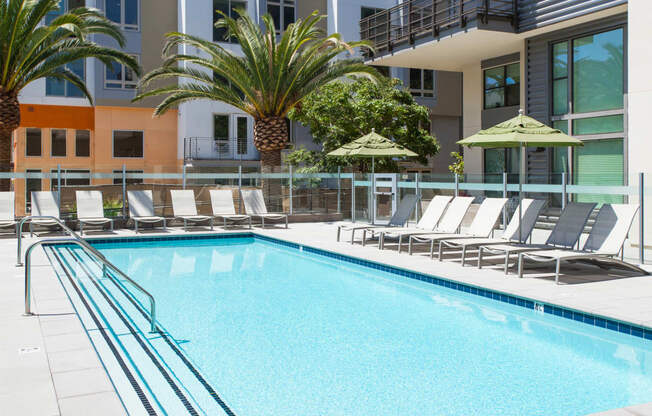 outdoor pool with lounge chairs and exterior of building