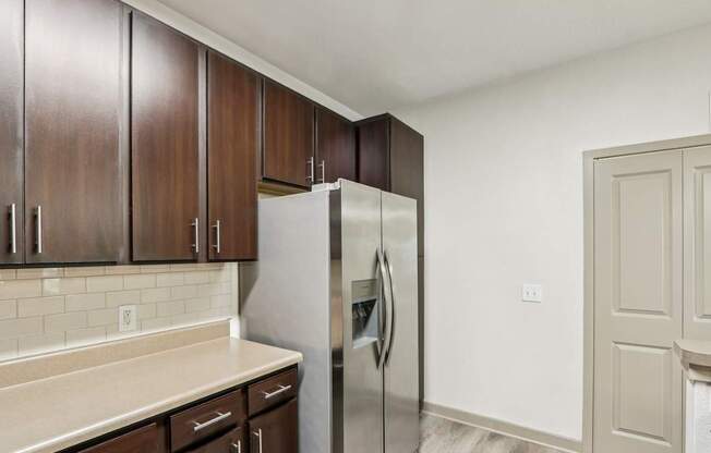 Royal Palm kitchen with brown cabinets and a stainless steel refrigerator at Oakleaf Plantation apartments in Jacksonville, FL.