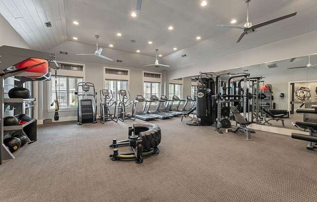 A spacious gym with a variety of equipment including treadmills, weights, and a bench press.