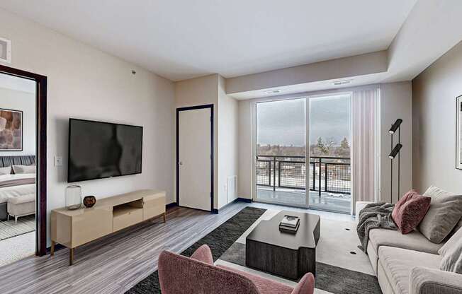 A modern living room with a large window overlooking a balcony.