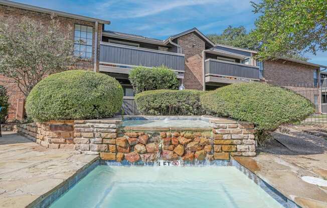 Fountain feature of the pool with apartments in the background at The Pearl apartments in Shreveport, LA