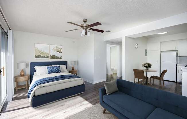 A bedroom with a large bed and a living room with a couch.