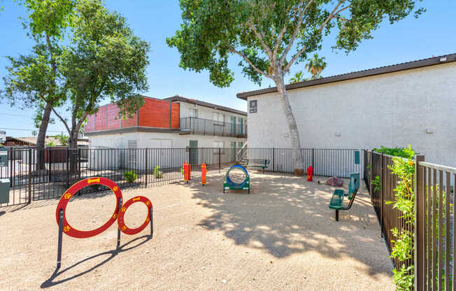 A playground with a red swing set and a green slide.