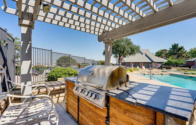 a patio with a grill and a swimming pool