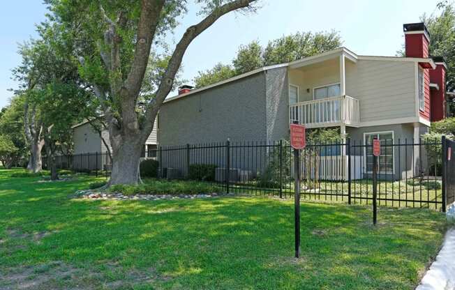 a fence with a red sign on it in front of a house