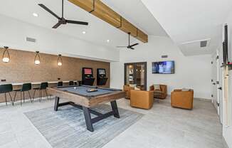 A room with a pool table and a television.