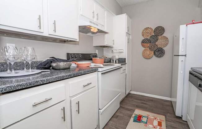 A kitchen with white cabinets and a gray counter top at Maplewood apartments in Shreveport, LA.