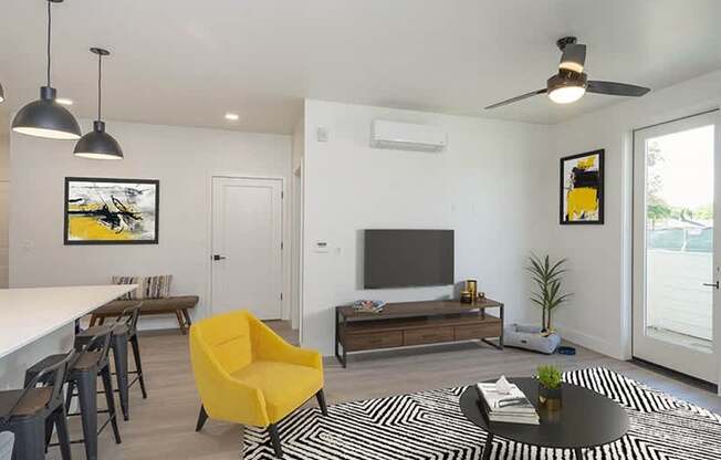 A living room with a yellow chair and a black and white rug.