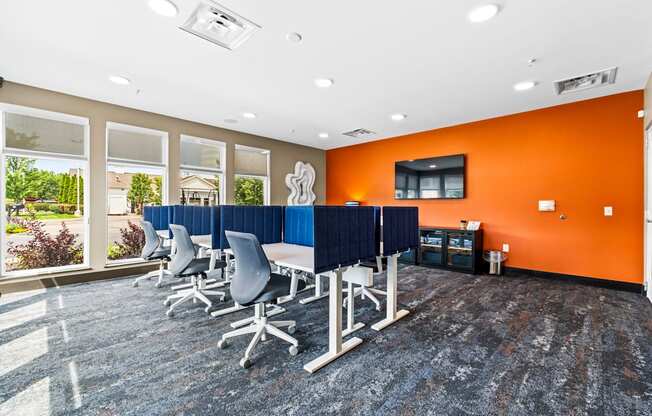 A conference room with orange walls and a long table with chairs.