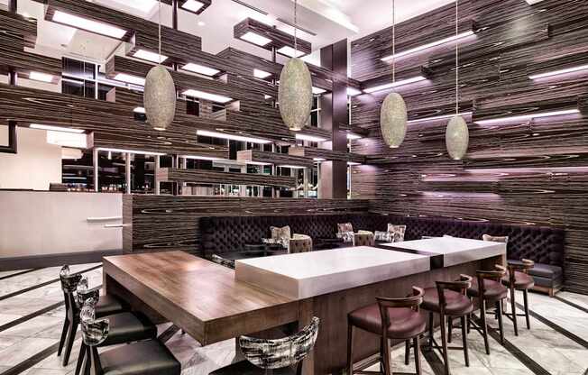 A modern dining area with a long wooden table and chairs.