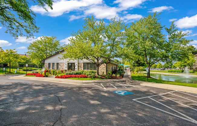 A parking lot with a building in the background and a blue handicap parking sign.