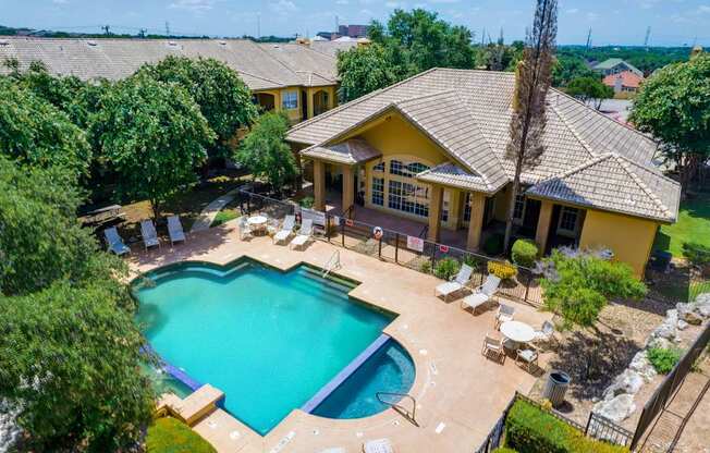 a aerial view of a pool and a house